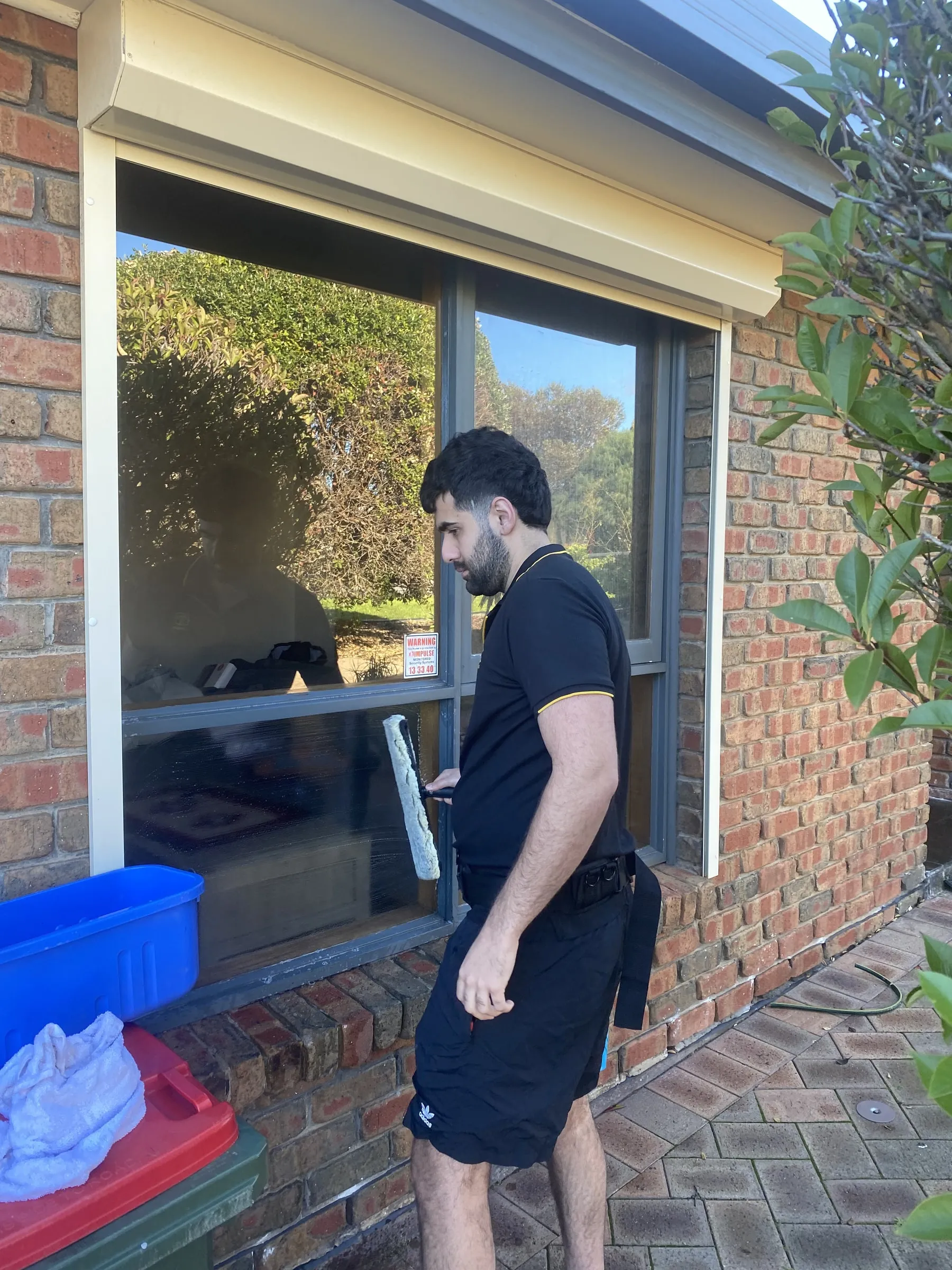Ben cleaning a residential window with a squeegee