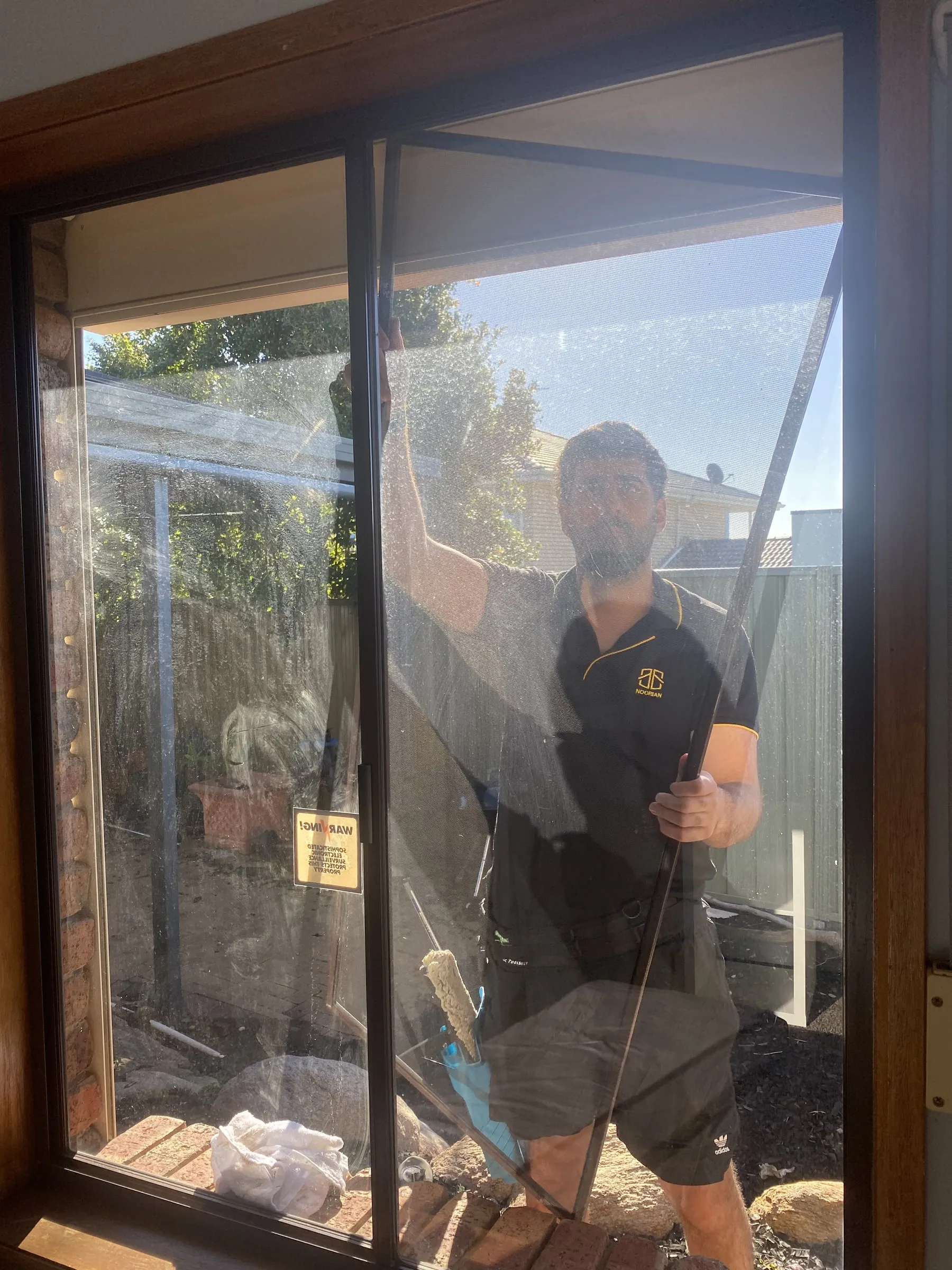 Cleaning a commercial window, seen through the glass