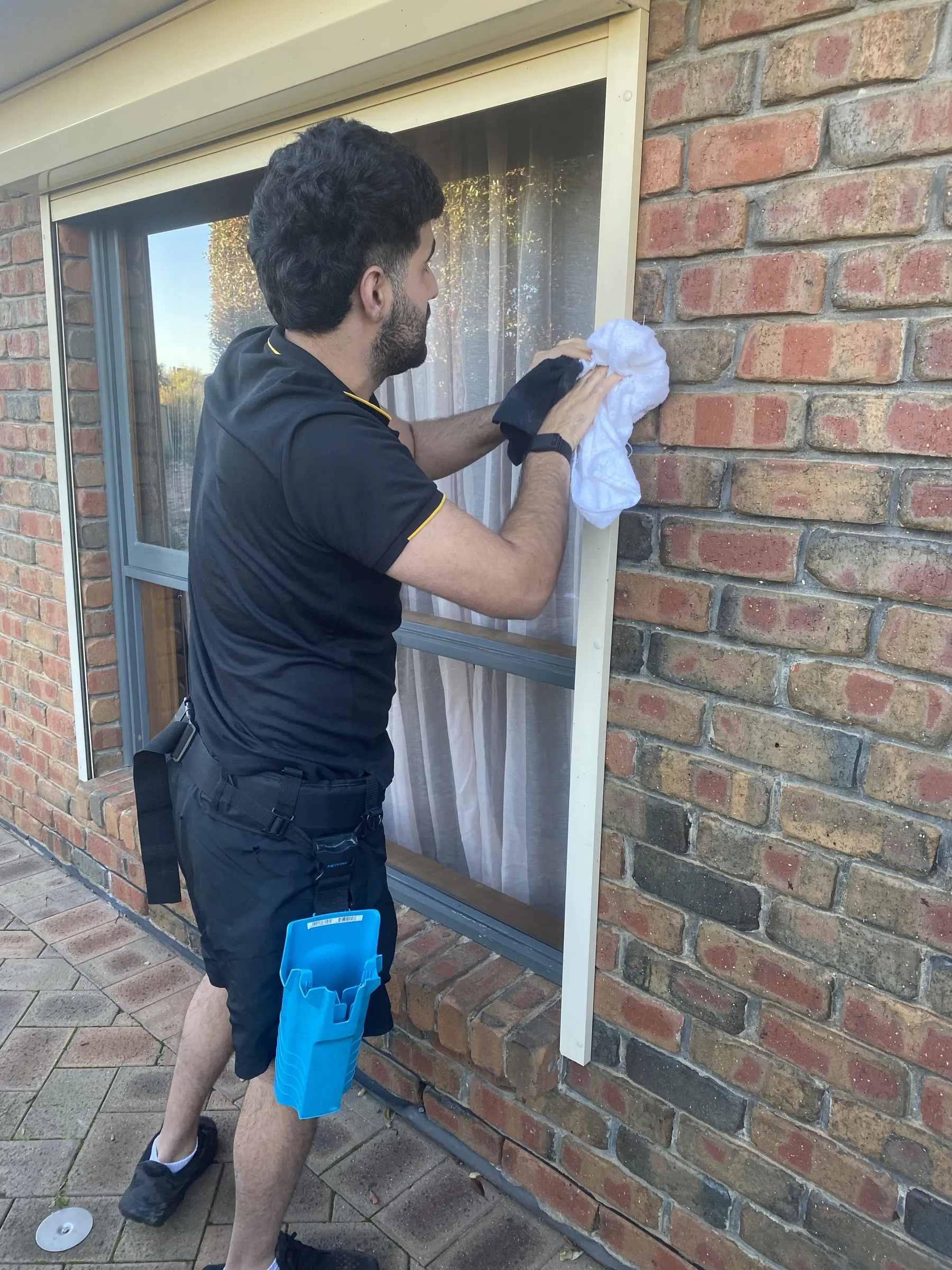 Wiping down a window frame by hand